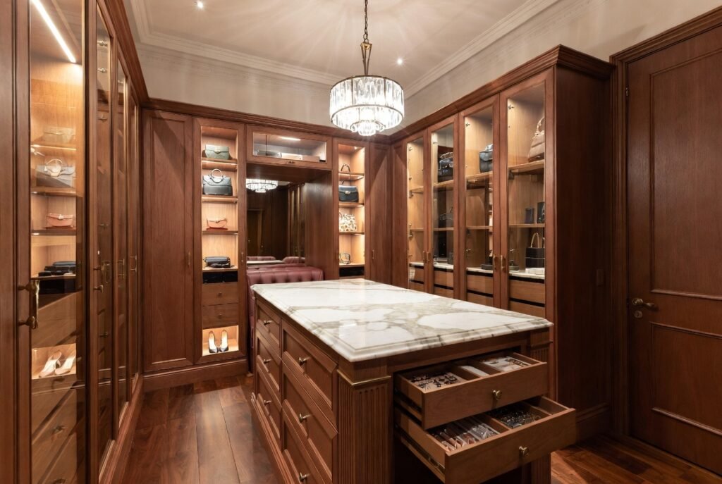 Luxury walk-in wardrobe island with Calacatta marble top, velvet-lined jewellery drawers and built-in upholstered seating in Malvern Edwardian home 2026 by Silk Touch Joinery